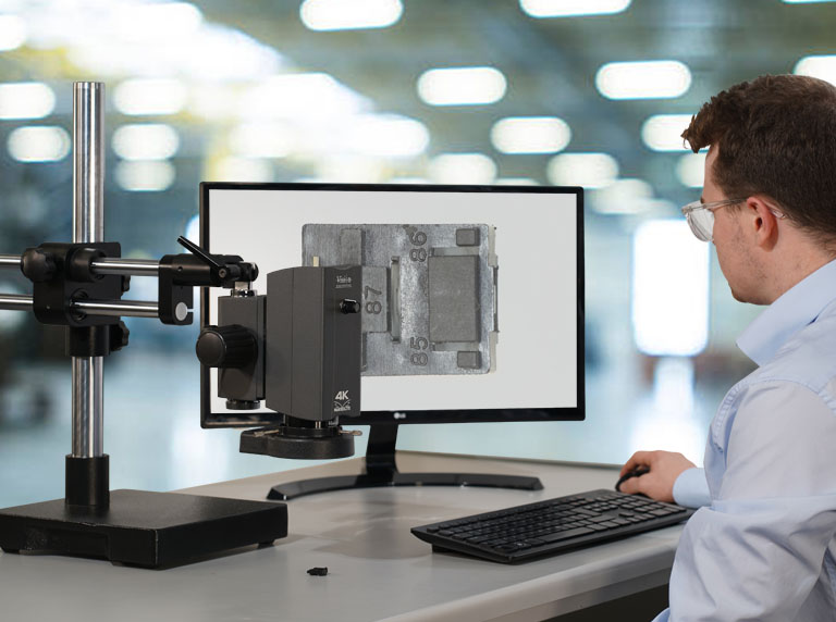 Man using Makrolite 4K digital-microscope inspecting black plastic component