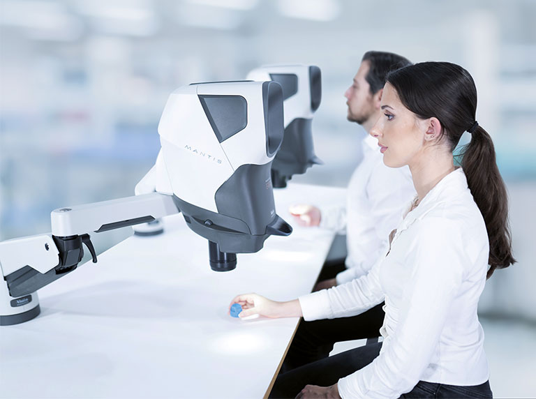 man and woman using Mantis stereomicroscopes